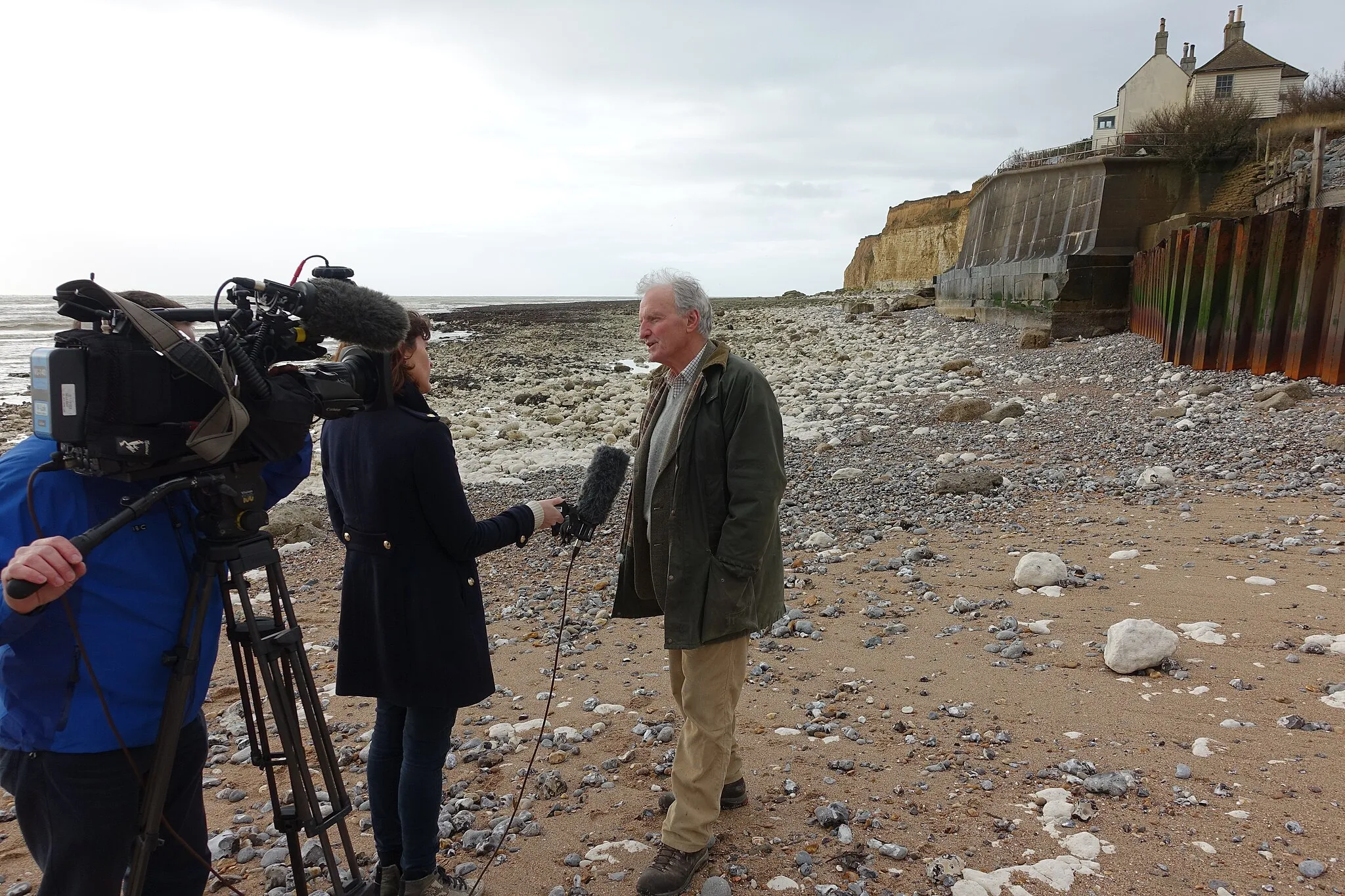 Photo showing: A representative from the Cuckmere Haven SOS campaign talks to the BBC about erosion of the cliff beneath the iconic Coastguard Cottages