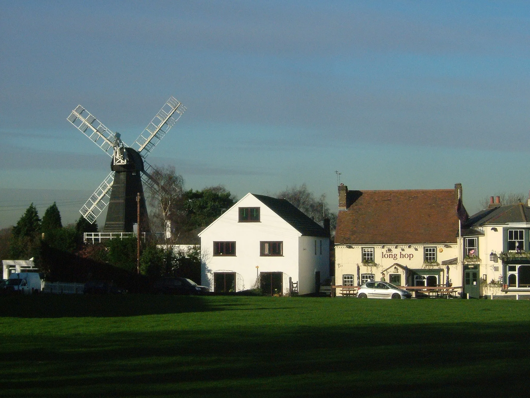 Photo showing: Meopham in Kent, is a linear village in Kent, England. The mill was built in 1801 by the Killick Brothers from Strood.
The Long Hop pub and the windmill on Meopham Green. Cricket is played here in summer. The name of the pub is a pun on a cricketing term and a reference to the hops that were grown locally.

Camera location 51° 21′ 42.12″ N, 0° 21′ 18″ E View this and other nearby images on: OpenStreetMap 51.361700;    0.355000