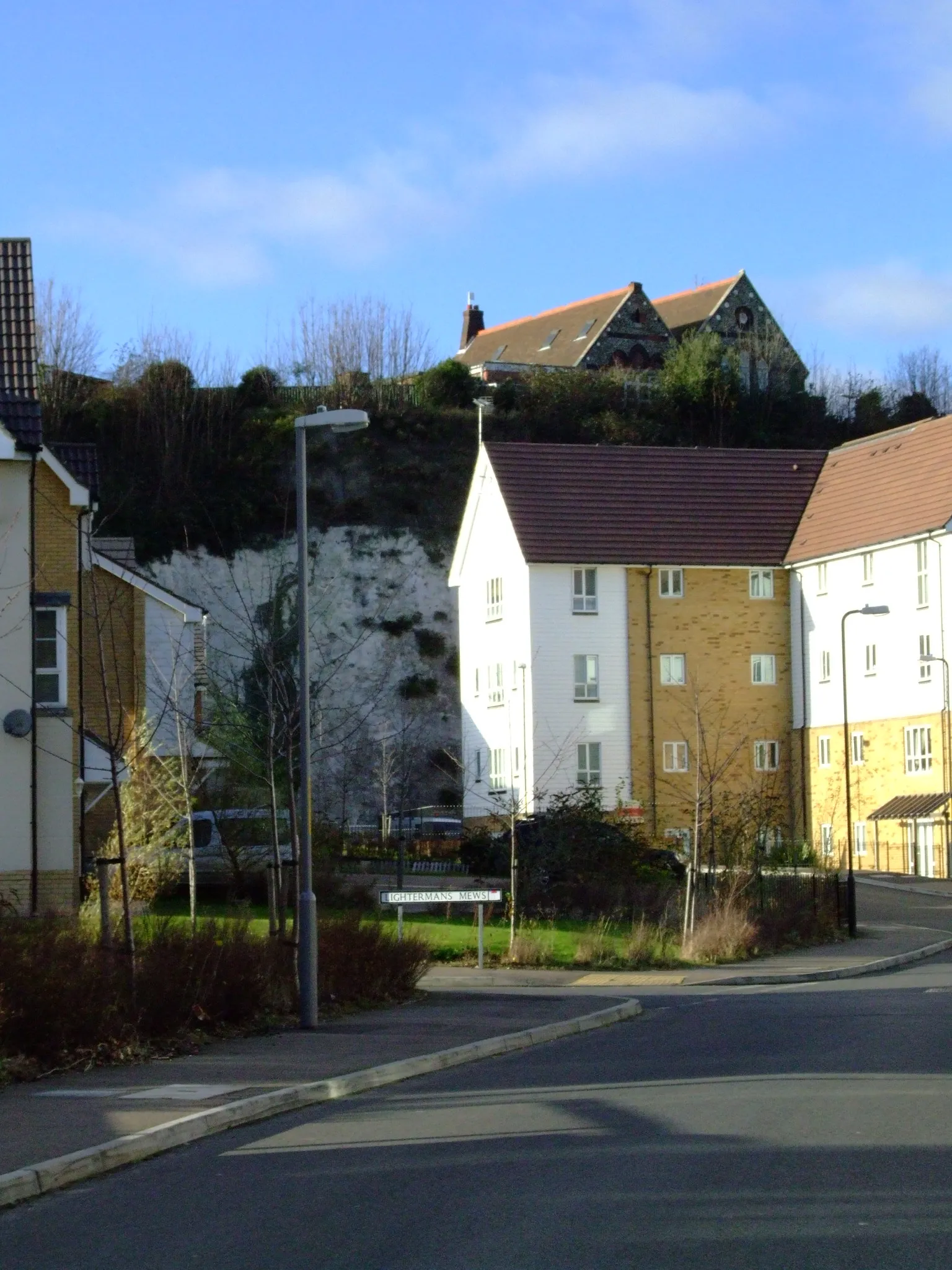 Photo showing: Northfleet merges with Gravesend in Kent. It is on the River Thames estuary. The shore has been excated for chalk, and heavy industry used the recovered land.. 
Rosherville Road passes from one chalk pit to the next, while the London Road (later caller Overcliffe) perches on the residual chalk. Recent housing development in one pit.

Camera location 51° 26′ 28.32″ N, 0° 20′ 47.4″ E View this and other nearby images on: OpenStreetMap 51.441200;    0.346500