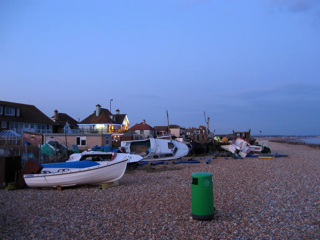 Photo showing: Boats on the Shingle Pulled up away from the sea and located between Pevensey Bay Aqua Club and The Moorings public house.