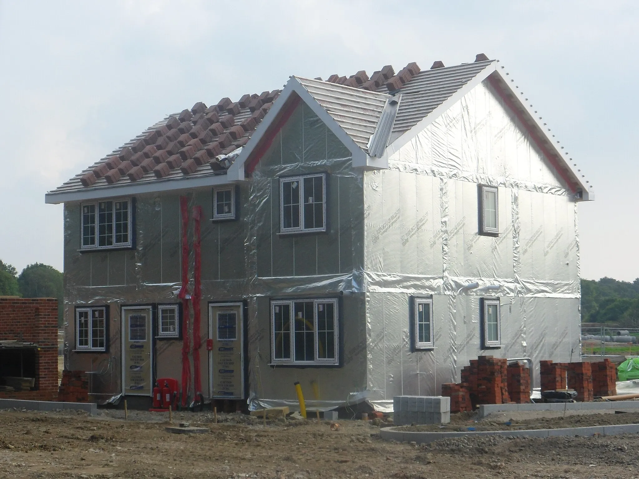 Photo showing: One of a series of photos chronicling the development of Crawley New Town's 14th residential neighbourhood, Forge Wood. The very first house to be built out of a total of 1,900 over the next 12 years.  It is seen in a nearly complete state in September 2014.