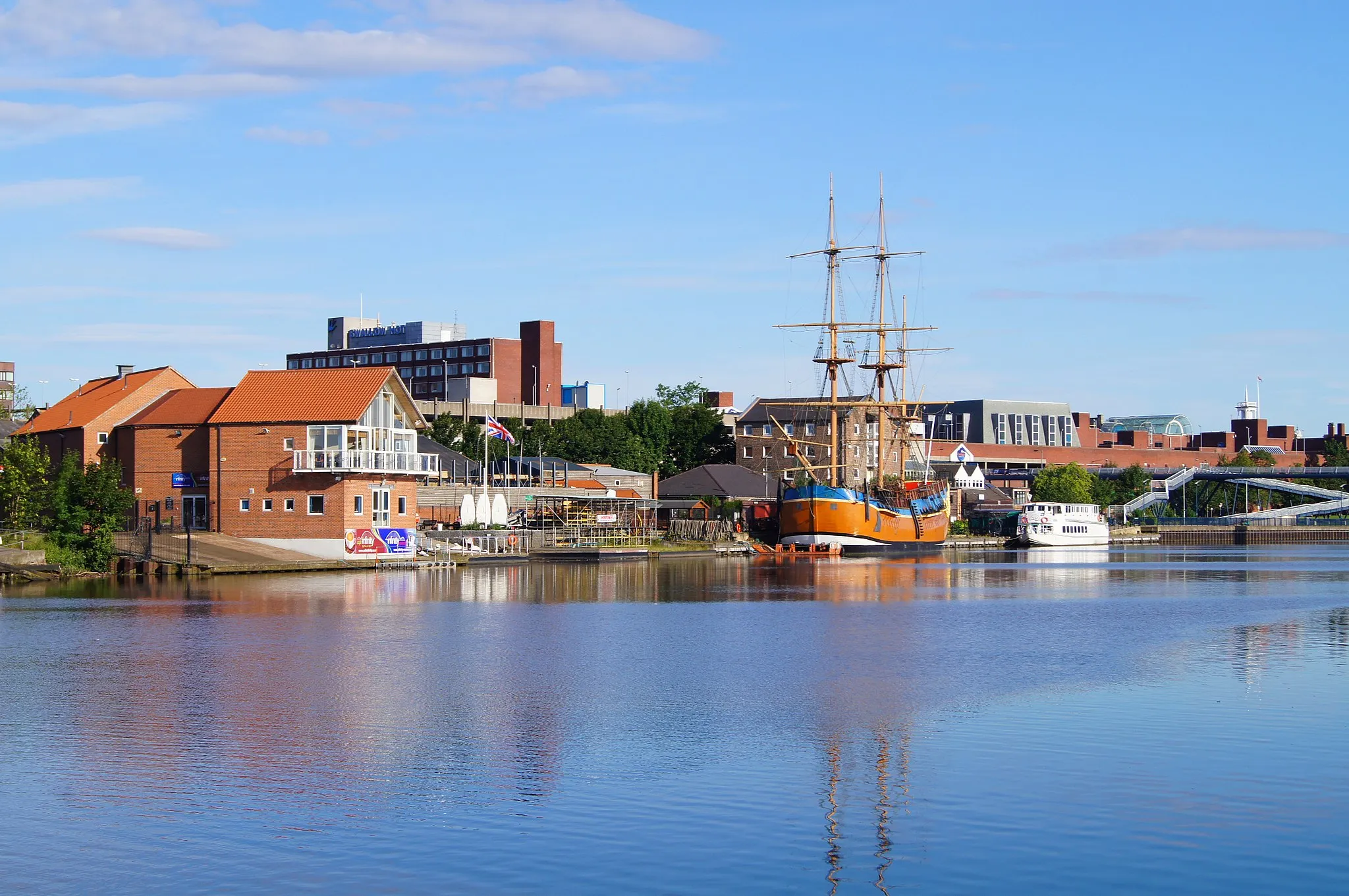 Photo showing: Castlegate Quay viewed from Teesdale Park on the south bank of the River Tees. The replica of Captain James Cook's tall ship, HM Bark Endeavour and the Teesside Princess river cruise boat are visible at the quayside.