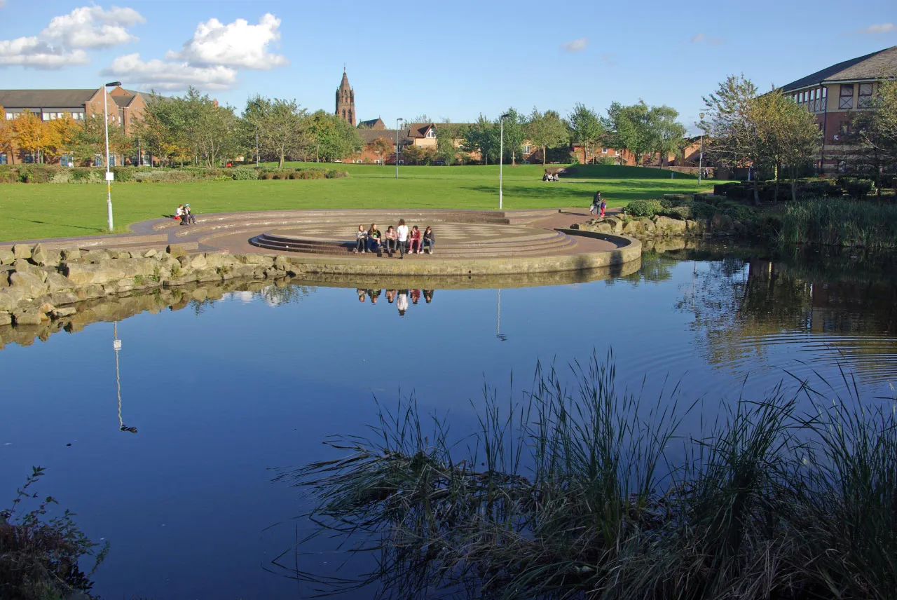 Photo showing: A group of young people taking advantage of the Autumn sunshine, seen from outside the MIMA building.