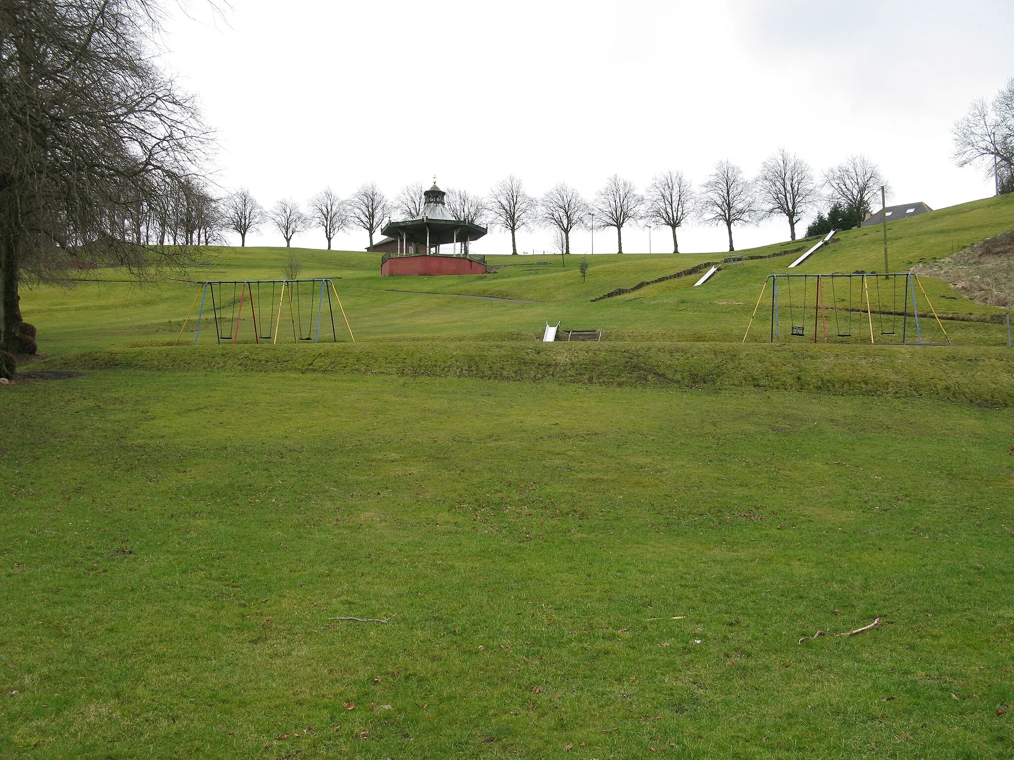 Photo showing: Alexander Hamilton Memorial Park The Alexander Hamilton Memorial Park, along with the bandstand, was presented to the village by Alexander Hamilton in May 1925. The bandstand, in the centre of the photograph, originated from the Great Glasgow Exhibition of 1911.