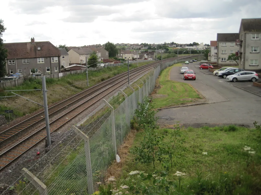 Photo showing: Drumgelloch 1st railway station (site), Lanarkshire Opened by British Rail in 1989 as the terminus of the line from Glasgow, this station closed in 2010 when the line was reopened through to Bathgate. View west towards Airdrie and Glasgow. Taken from slightly higher than NS7765 : Drumgelloch 1st station, Lanarkshire.
A new Drumgelloch station was opened in 2010 close to the site of what had previously been Clarkston station, some 500m closer to Edinburgh, behind the camera position.