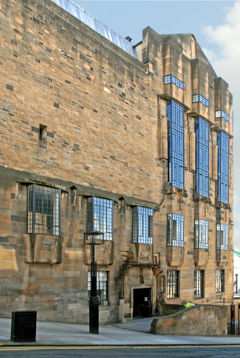 Photo showing: La façade ouest de la "Glasgow School of Art".
Les trois fenêtres en hauteur sont celles de la bibliothèque (1907-1909) conçue par Mackintosh (y compris le mobilier), qui occupe trois étages.
Charles Rennie Mackintosh (1868-1928) est un architecte, peintre et designer, né à Glasgow, qui est considéré comme un des principaux précurseurs du mouvement moderne.
Avec Margaret Macdonald, qui est devenue son épouse en 1900, son ami Herbert McNair et son épouse Frances Macdonald, la soeur de Margaret, tous issus de la "Glasgow School of Art", il a constitué un groupe d'artistes très novateurs pour l'époque appelé "The Four", influencé par l'Art Nouveau, le Symbolisme et par le mouvement anglais "Arts and Crafts".
En 1896, Mackintosh, alors âgé de 28 ans, a gagné le concours d'architecture du nouveau bâtiment de la "Glasgow School of Art". Ce bâtiment entièrement conçu par lui et ses collaborateurs a fondé le "Glasgow style" (art nouveau écossais), il a été construit en deux étapes. L'aile ouest a été terminée en 1910, elle comprend la bibliothèque considérée avec la façade du bâtiment comme le chef-d'oeuvre de Mackintosh.

www.gsa.ac.uk/