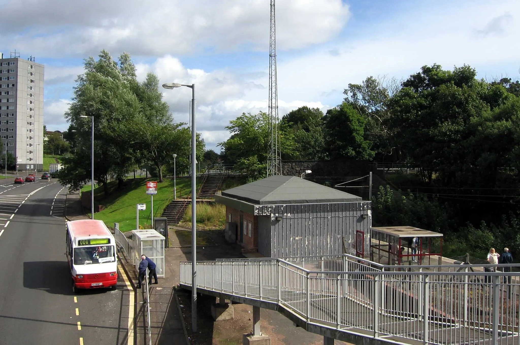 Photo showing: Branchton railway station lies on the edge of the Branchton area of Creenock, Scotland. View from the footbridge across the main road south to Inverkip, looking north towards Greenock town centre.