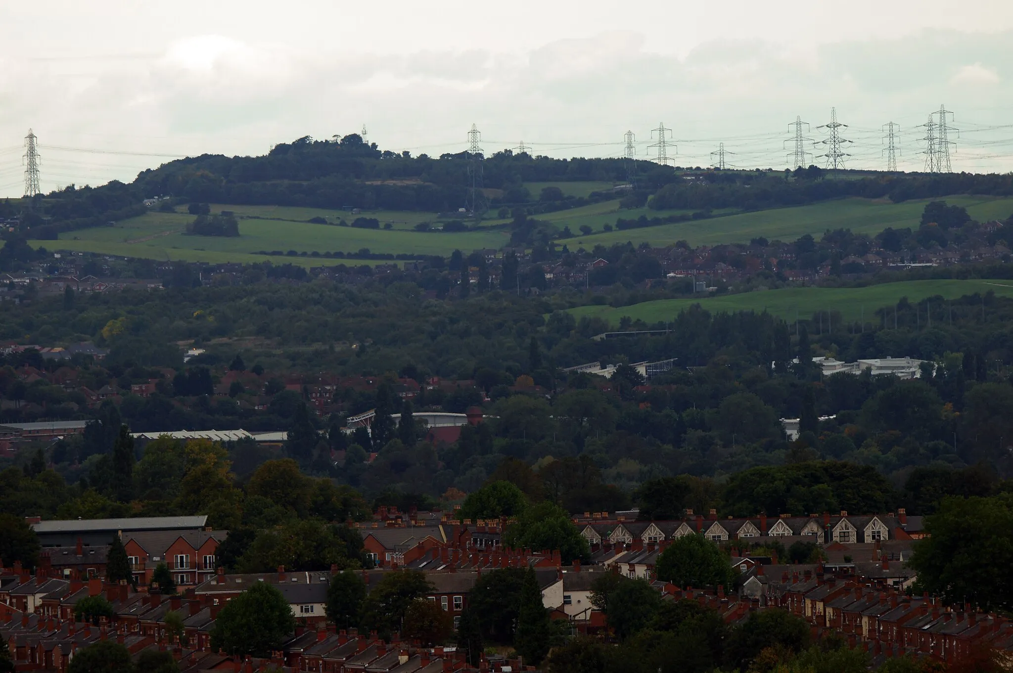 Photo showing: Barr Beacon, near Walsall, England. View from due south, photographed from the Library of Birmingham (distance 10 km). In the right of the middle ground is Perry Beaches College.