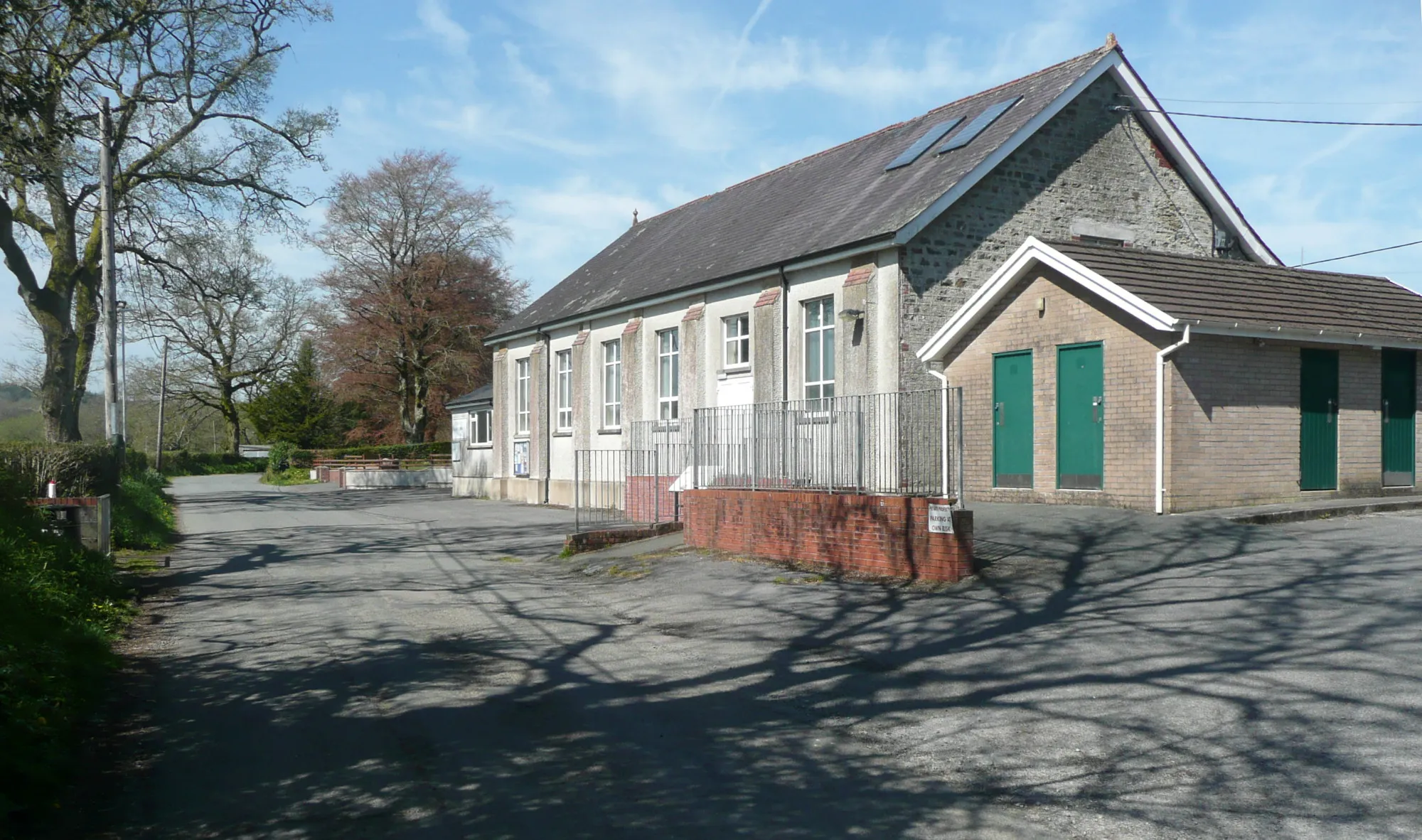 Photo showing: The village hall and conveniences, Llanpumsaint. There is also a small car park to the right.