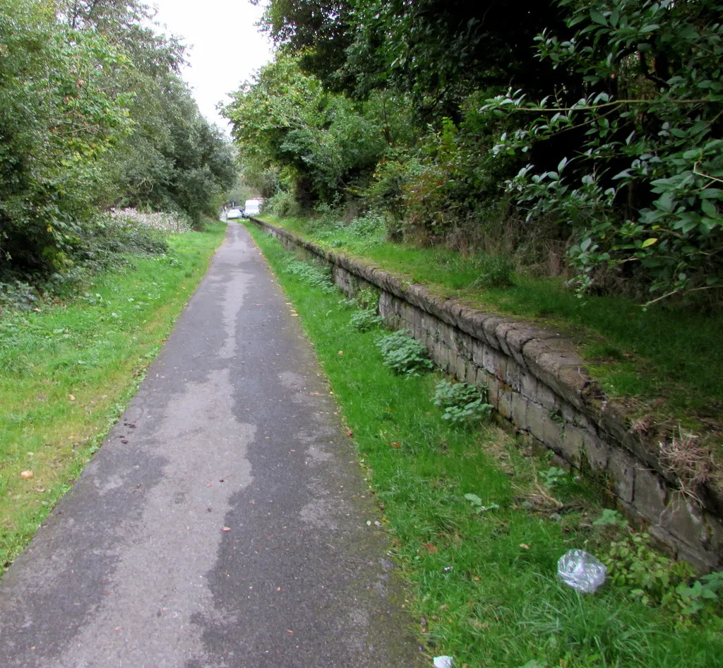 Photo showing: Path past the remains of Wyndham Halt station. A cycle route and footpath through the Ogwr Fawr valley use a former railway route, here past the remains of the platform at Wyndham Halt station which closed in 1958. Opened in 1942, the halt served the village of Wyndham, the Wyndham Colliery and Penllwyngwent Colliery.