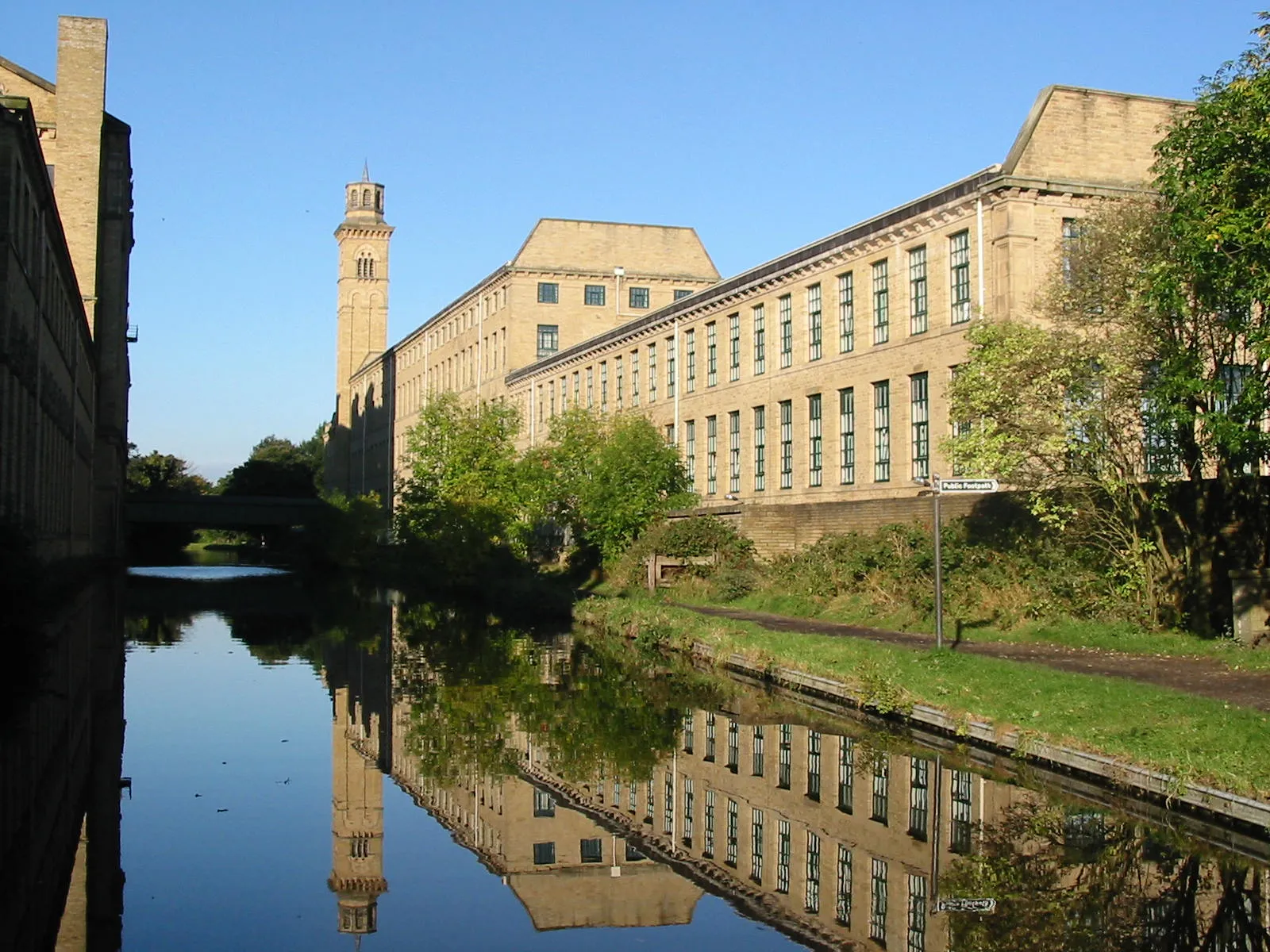 Photo showing: Titus Salt's mill in Saltaire, Bradford is an UNESCO World Heritage Site. Leeds to Liverpool Canal, Saltaire. Mill buildings built by Sir Titus Salt. Saltaire mills from the Leeds and Liverpool Canal. Salts Mill (left) and the New Mill (right) from the Leeds and Liverpool Canal.