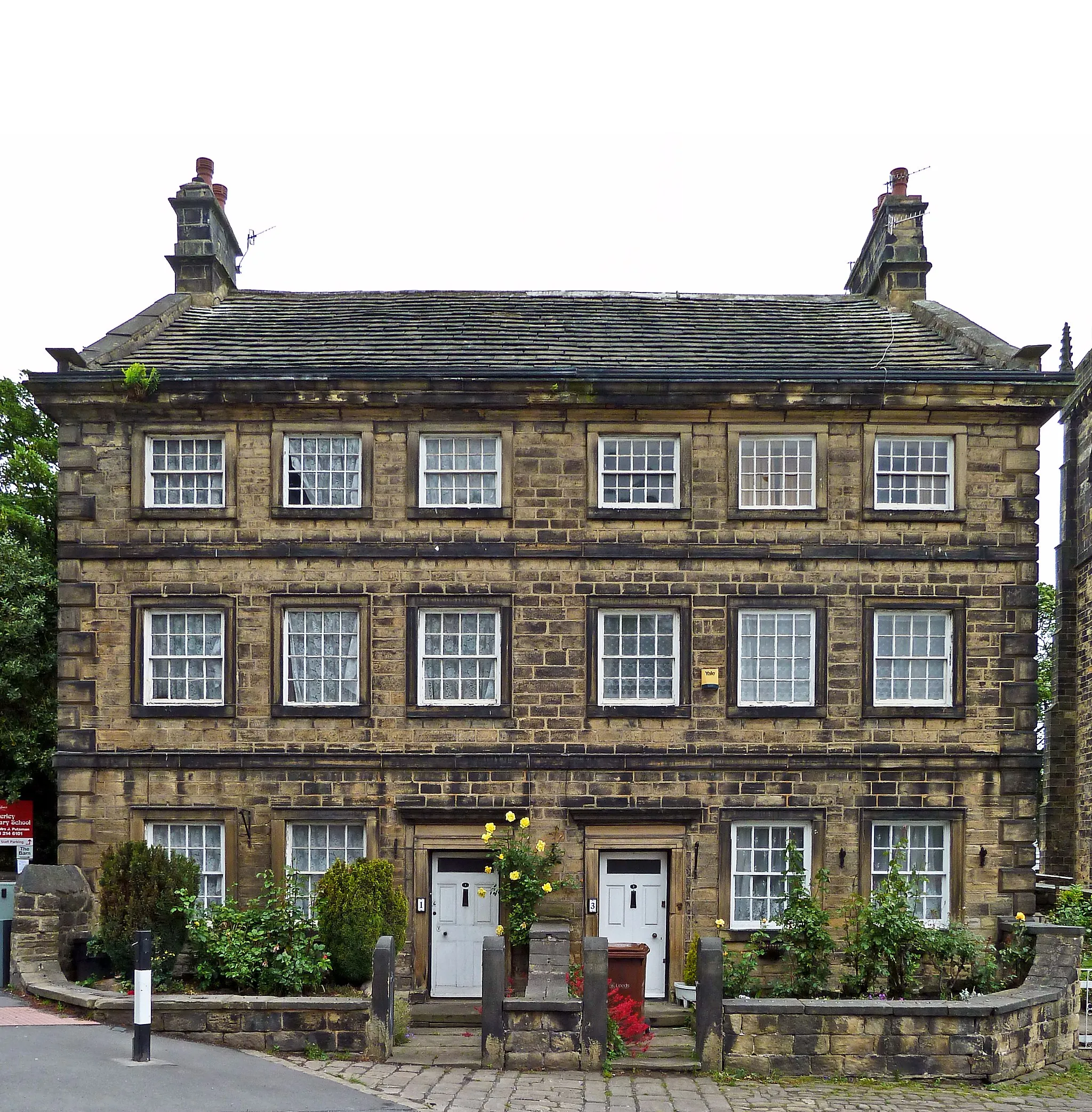 Photo showing: Grade 2*. Large pair of semi-detached houses. Mid C18 with rear service block added c1800. Well-coursed dressed stone to front, harrier-dressed stone to sides and rear, stone slate roof. 3 storeys and attics, double-depth. 6-bay symmetrical facade. Raised chamfered quoins, lst- and 2nd-floor bands, eaves cornice. Central 2 bays have identical doorways with architraves, pulvinated friezes and cornices. All windows have raised square surrounds and retain 16-pane sashes except those to second floor which has smaller windows with 20-pane sashes. Coped gables with kneelers and end stacks. Rear plainer with recessed flat-faced mullion windows. Left-hand return has similar windows and taking-in door (blocked) to each of the upper floors. Right-hand return, facing into the churchyard and therefore open to public view, has 4 ground-floor windows as front (some blocked) and some to upper-floor outer bays.
Interior: stair-halls with relatively late staircases separated from each other by a thick stone wall, each hall partitioned from the front parlours by another stone wall. Rear rooms have 2 spine beams and corner fireplaces.
A house of fine stone detail prominently sited next to the church and unusual in being an early example of semi-detached housing.

www.britishlistedbuildings.co.uk/en-423114-church-house-1...