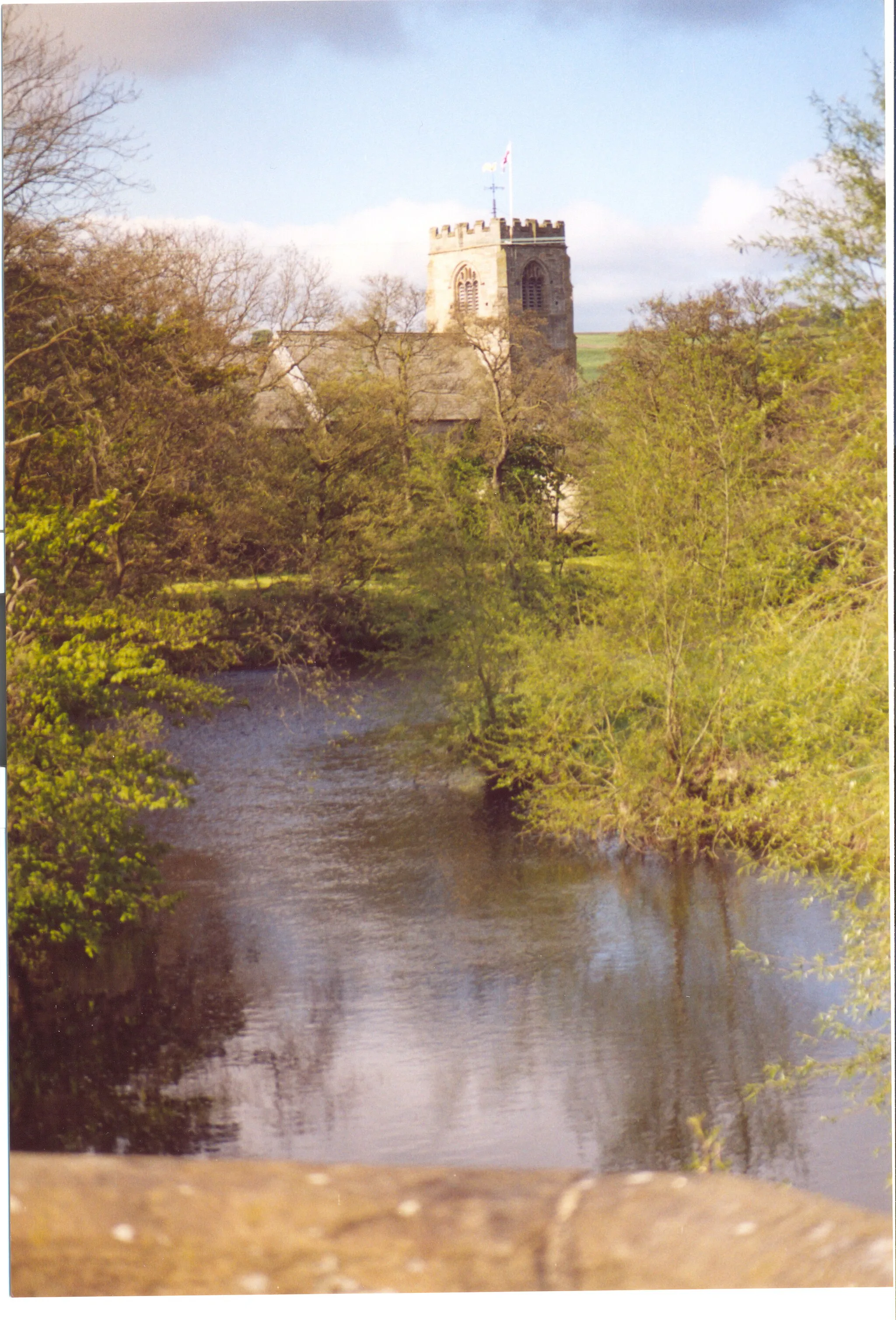 Photo showing: A view of the church of St Thomas a'Becket from Hampsthwaite Bridge across the River Nidd