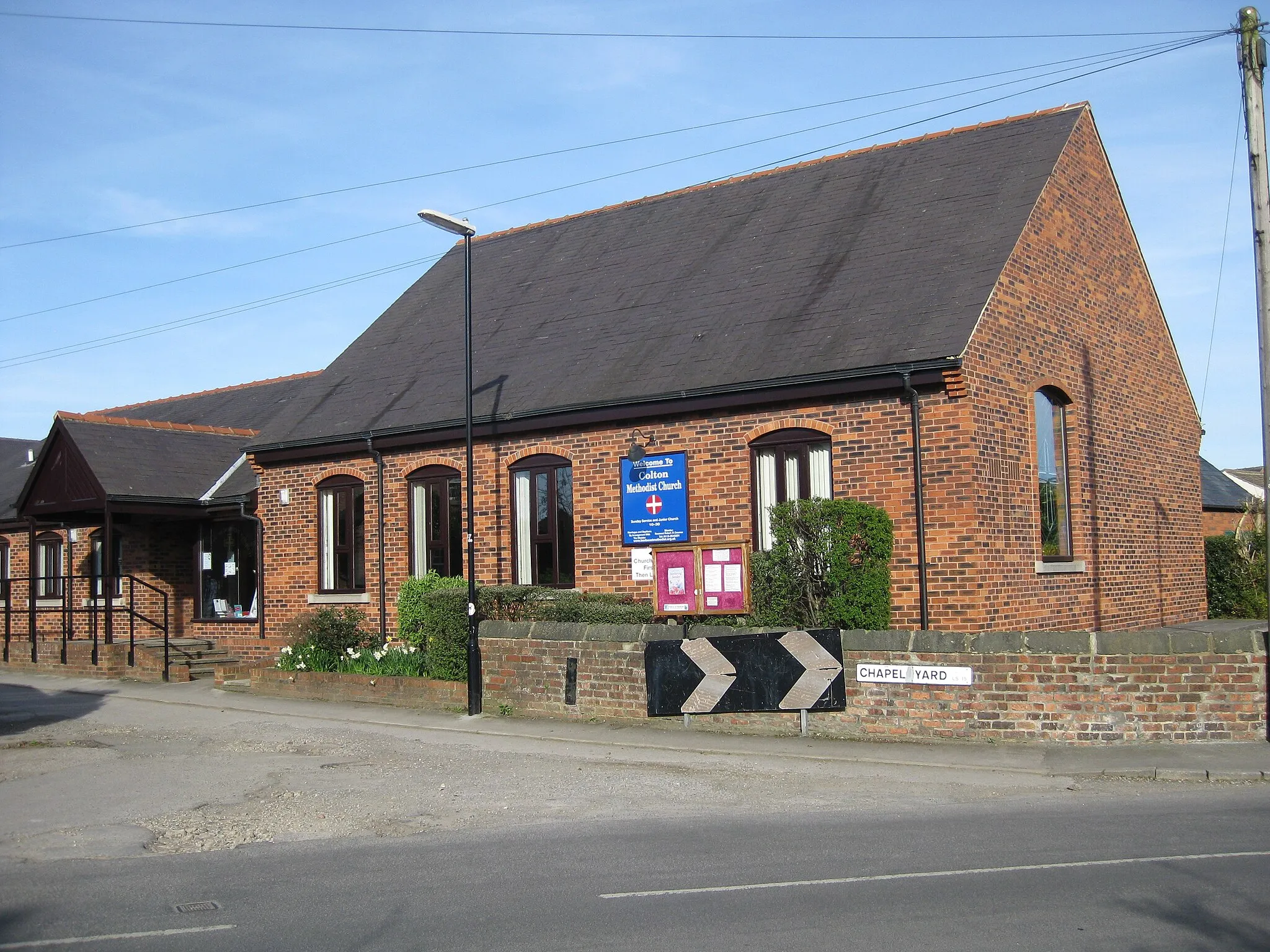 Photo showing: Colton Methodist Church, Chapel Yard, Colton, Leeds LS15 9AH. Viewed from Meynell Road. Brick building with slate roof.  The street sign "Chapel Yard" is visible on a low wall.