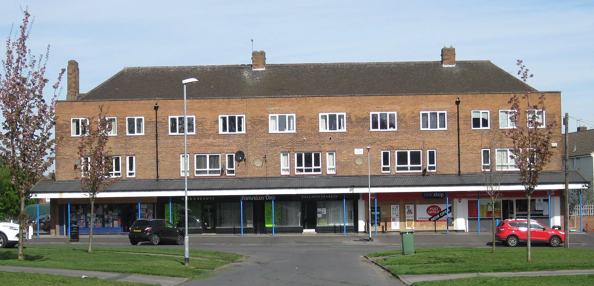 Photo showing: Shops on Stanks Parade, Swarcliffe, Leeds LS14.  3-storey terrace with shops on ground floor and two floors above, sharing a common roof.